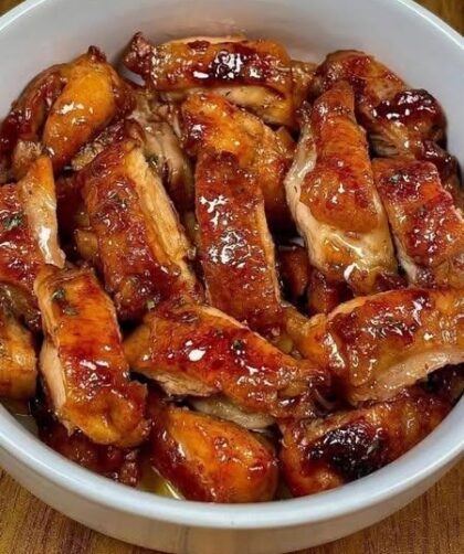 Honey Glazed Chicken Thighs Recipe (Crispy, Sticky, and Full of Flavor) If you are searching for a delicious chicken dinner that is easy to prepare, packed with bold flavors, and perfect for busy weeknights, this Honey Glazed Chicken Thighs recipe is an excellent choice. Juicy chicken thighs are lightly coated with cornstarch to create a delicate crispy crust before being seared until golden brown. They are then tossed in a rich homemade honey glaze made with soy sauce, garlic, fresh ginger, sesame oil, and chili crunch. The result is tender chicken covered in a glossy, sweet, savory, and slightly spicy sauce that tastes like it came from your favorite restaurant. One of the reasons chicken thighs are so popular is their ability to stay moist throughout cooking. Unlike lean chicken breasts, thighs contain a little more fat, which helps them remain juicy even when cooked over higher heat. This makes them ideal for recipes that require pan-searing because they develop a flavorful crust while keeping the inside tender and succulent. Another standout feature of this recipe is the light cornstarch coating. Instead of using breadcrumbs or deep frying, a thin dusting of cornstarch creates a crisp exterior that locks in moisture while giving the glaze something to cling to. Every bite delivers a satisfying combination of crispy edges and sticky sauce. Whether you serve this chicken over steamed rice, with roasted vegetables, or alongside creamy mashed potatoes, it is guaranteed to become a family favorite. Why You'll Love This Recipe There are many reasons this honey glazed chicken recipe deserves a place in your regular dinner rotation. Ready in approximately 30 minutes. Uses simple pantry ingredients. Crispy without deep frying. Sweet, savory, and slightly spicy flavors. Perfect for meal prep. Family-friendly and customizable. Budget-friendly ingredients. High in protein. Delicious with a variety of side dishes. Better than takeout while being easy enough for beginner cooks. Ingredients For the Chicken 8 boneless, skinless chicken thighs 3 tablespoons cornstarch 1 teaspoon salt ½ teaspoon black pepper 2 tablespoons olive oil For the Honey Glaze ¼ cup low-sodium soy sauce ⅓ cup honey 1 tablespoon sesame oil 1 tablespoon chili crunch 4 garlic cloves, minced 1 tablespoon freshly grated ginger Garnish 2 teaspoons sesame seeds 2 tablespoons chopped fresh chives Equipment Needed Having the right equipment makes the cooking process easier. Large cast iron skillet or stainless steel pan Small mixing bowl Whisk Measuring cups Measuring spoons Tongs Plate Paper towels Wooden spoon Step 1: Prepare the Chicken Remove the chicken thighs from the refrigerator about 10 minutes before cooking. Allowing the meat to rest at room temperature helps it cook more evenly. Use paper towels to pat each chicken thigh completely dry. Removing excess moisture is one of the most important steps because it helps the chicken brown properly rather than steam. Season both sides with salt and black pepper. Spread the cornstarch evenly onto a large plate. Press each chicken thigh into the cornstarch until both sides are lightly coated. Shake off any excess coating. A thin layer works much better than a thick coating because it creates a delicate crisp texture without becoming heavy. Step 2: Prepare the Honey Glaze In a small bowl combine: Honey Soy sauce Sesame oil Chili crunch Garlic Fresh ginger Whisk until smooth. Preparing the sauce ahead of time keeps the cooking process simple because the chicken cooks quickly once it reaches the hot skillet. Step 3: Heat the Pan Place a large skillet over medium-high heat. Add the olive oil and allow it to heat until shimmering. A properly heated pan helps create a beautiful golden crust that adds tremendous flavor. Step 4: Sear the Chicken Carefully place the chicken thighs into the hot skillet. Leave space between each piece. Avoid overcrowding the pan because crowded chicken releases moisture and prevents proper browning. Cook for about 3 to 4 minutes without moving the chicken. Flip each thigh using tongs. Cook another 3 to 4 minutes on the opposite side. Continue cooking until the internal temperature reaches 165°F (74°C). Transfer the cooked chicken to a clean plate. Step 5: Make the Sticky Honey Glaze Reduce the heat to medium-low. Pour the prepared honey glaze into the same skillet. Use a wooden spoon to scrape up all the browned bits left behind from cooking the chicken. These flavorful bits dissolve into the sauce and create incredible depth. Allow the glaze to simmer gently for approximately 3 minutes. As it cooks, the honey naturally thickens into a glossy coating. Stir occasionally to prevent sticking. Step 6: Coat the Chicken Return the cooked chicken thighs to the skillet. Turn each piece several times until fully coated. Spoon the glaze repeatedly over the chicken. Cook for another 2 minutes so the sauce clings to every surface. The finished glaze should appear shiny, thick, and sticky. Step 7: Garnish and Serve Remove the skillet from the heat. Sprinkle sesame seeds over the chicken. Top with freshly chopped chives. Serve immediately while hot. Serving Suggestions This chicken pairs beautifully with many side dishes. Steamed Rice Fluffy white rice absorbs every drop of the delicious glaze. Jasmine Rice Its fragrant aroma complements the sesame and ginger perfectly. Brown Rice A hearty, wholesome option that adds extra fiber. Roasted Potatoes Crispy roasted potatoes create a comforting combination. Mashed Potatoes Creamy potatoes balance the bold flavors of the sauce. Stir-Fried Vegetables Bell peppers, broccoli, carrots, snap peas, and mushrooms make excellent companions. Fresh Salad A crisp green salad provides freshness that balances the rich glaze. Noodles Rice noodles or egg noodles are another fantastic serving option. Why Cornstarch Works Cornstarch plays a unique role in this recipe. When heated, cornstarch forms a delicate crust around the chicken. Unlike flour, it creates a lighter, crispier texture. It also helps the sauce cling to every bite. Instead of sliding off, the glaze sticks beautifully to the crispy coating. This technique is commonly used in many Asian-inspired recipes because it creates restaurant-quality texture without requiring deep frying. Why Chicken Thighs Are Best Chicken thighs contain slightly more fat than chicken breasts. That extra fat helps prevent dryness during cooking. They remain juicy even after being coated and seared. The richer flavor also pairs exceptionally well with soy sauce, garlic, ginger, and honey. Boneless skinless thighs cook quickly and evenly, making them ideal for weeknight dinners. Tips for Success Pat the chicken completely dry before coating. Shake off excess cornstarch. Heat the skillet thoroughly before adding oil. Avoid overcrowding the pan. Let the chicken cook undisturbed while searing. Reduce the heat before adding the honey glaze. Stir the sauce occasionally. Do not overcook the chicken. Garnish just before serving. Serve immediately for the best texture. Easy Variations Make It Spicier Add extra chili crunch or crushed red pepper flakes. Add Citrus Mix in one teaspoon of fresh lime juice just before serving. Extra Garlic Double the garlic for a richer flavor. Maple Version Replace honey with pure maple syrup for a deeper sweetness. Ginger Lover's Version Increase the fresh ginger for a brighter, more aromatic sauce. Vegetable Addition Cook broccoli, carrots, bell peppers, or snow peas in the same skillet before returning the chicken. Storage Instructions Allow leftovers to cool completely before storing. Place the chicken in an airtight container. Refrigerate for up to 4 days. For longer storage, freeze in a freezer-safe container for up to 3 months. Label the container with the date for easy tracking. Reheating Instructions For the best texture, reheat the chicken gently in a skillet over medium-low heat with a splash of water to loosen the glaze. Cook for about 5 to 7 minutes, turning occasionally until heated through. You can also microwave individual portions for 1 to 2 minutes, stirring or turning halfway through to ensure even heating. If frozen, thaw the chicken overnight in the refrigerator before reheating. Frequently Asked Questions Can I use chicken breast? Yes. Chicken breast works well, but it cooks more quickly and can dry out if overcooked. Check for an internal temperature of 165°F (74°C) and remove it from the pan as soon as it is done. Can I make this recipe ahead of time? Absolutely. Cook the chicken and glaze as directed, let it cool, and store it in the refrigerator. Reheat gently before serving for a quick and flavorful meal. Is this recipe very spicy? No. The chili crunch adds mild heat and texture. Adjust the amount to suit your taste, or omit it if you prefer a milder dish. Can I make it gluten-free? Yes. Substitute the soy sauce with a certified gluten-free tamari or gluten-free soy sauce, and confirm that your chili crunch ingredients are gluten-free. What vegetables go well with this dish? Broccoli, green beans, bok choy, zucchini, carrots, asparagus, bell peppers, and snap peas all pair wonderfully with the sweet and savory glaze. Final Thoughts honey glazed chicken